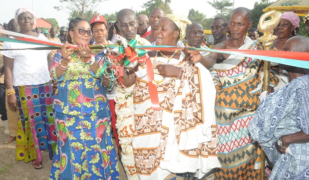 Mrs Lordina Mahama (left) with support form traditional authority to inaugurate  a teachers quarters in  Ampoma